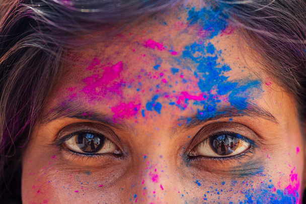 Holi Festival Of Colours. cropped portrait of happy indian girl in holi color. eyes close up - Фото, изображение