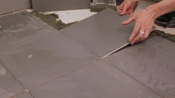 Robotnik układający płytki na podłodze - Materiał filmowy, wideo