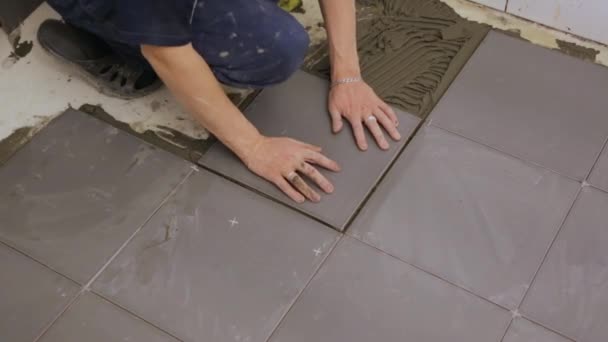 Pracovník pokládající dlaždice na podlahu - Záběry, video