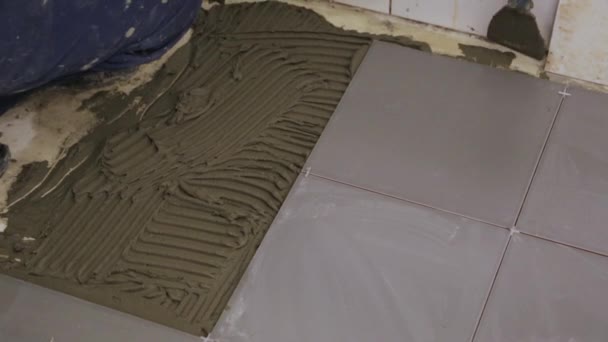 Працівник кладе клей для плитки на підлогу
 - Кадри, відео