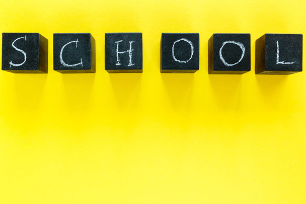 Blocchi con scuola titolo sullo sfondo giallo. Istruzione, ritorno al concetto di scuola. - Foto, immagini