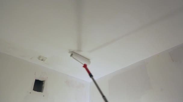 Werknemer schilderen plafond met witte verf - Video