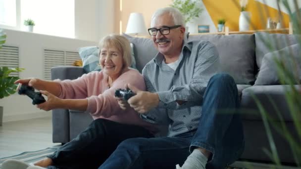 Happy family senior man and woman playing video game then laughing and doing high-five - Footage, Video