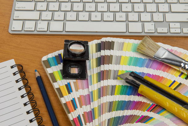 цветовая гамма со стилусом и увеличительным стеклом на нем и ноутбуком и клавиатурой, чтобы сформировать элемент творческой офисной среды
 - Фото, изображение
