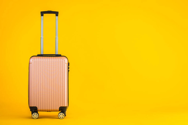 Różowy kolor bagażu lub bagażu wykorzystania do transportu podróży i wypoczynku na żółtym odosobnionym tle - Zdjęcie, obraz