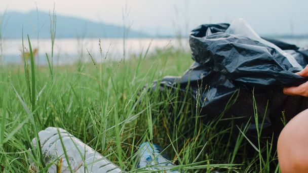 Jovens ativistas asiáticos felizes coletando resíduos plásticos na floresta. Voluntárias coreanas ajudam a manter a natureza limpa e pegar lixo. Conceito sobre problemas de conservação ambiental poluição. - Foto, Imagem