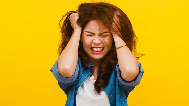 Portrait of young Asian lady with negative expression, excited screaming, crying emotional angry in casual clothing and looking at the camera over yellow background. Facial expression concept.  - Photo, Image