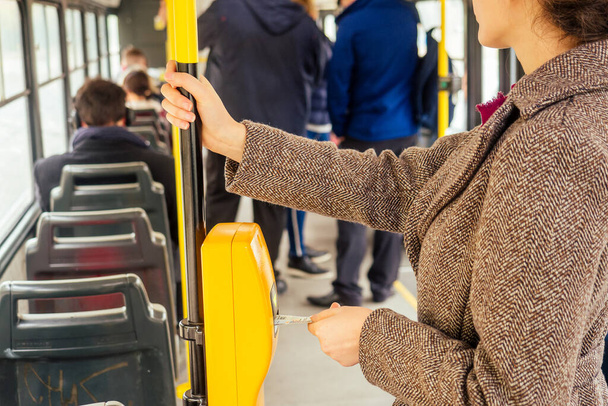 Młoda kobieta wkłada bilet autobusowy do kasjera, walidacji i tykając w Pradze sity Chezh - Zdjęcie, obraz