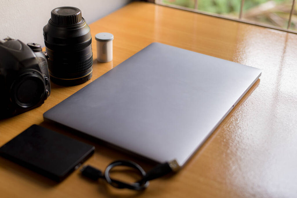 Ноутбук с объективом на столе в концепции рабочего пространства
. - Фото, изображение
