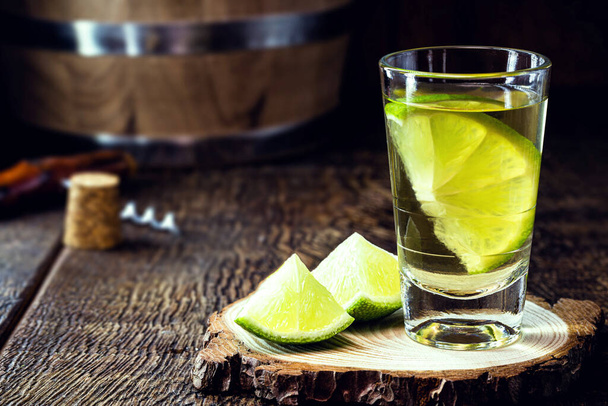 high quality distilled alcohol. Brazilian cachaca (called pinga) taken with lemon, drip, Russian vodka, white rum, vermont, soft tequila, ozo, sake or brandy. Drink on rustic wooden background. - Photo, Image