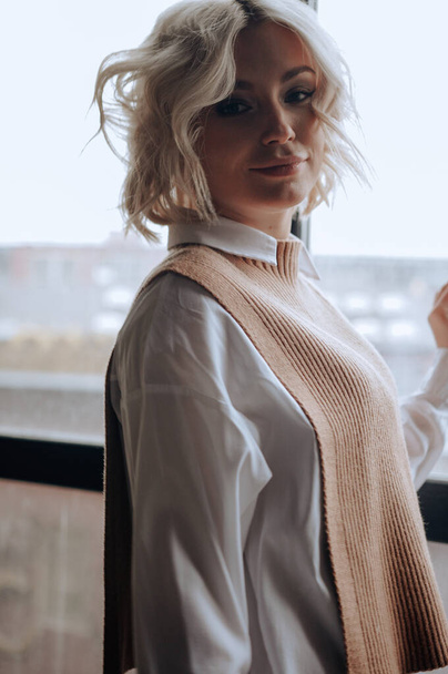 блондинка красива молода жінка в стильному одязі позує в інтер'єрі лофт
   - Фото, зображення
