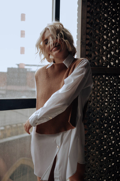 szőke gyönyörű fiatal nő elegáns ruhák pózol tetőtérben   - Fotó, kép