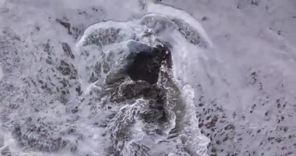Aerial view of waves crashing over rocks at the Batu Bolong beach - Materiał filmowy, wideo