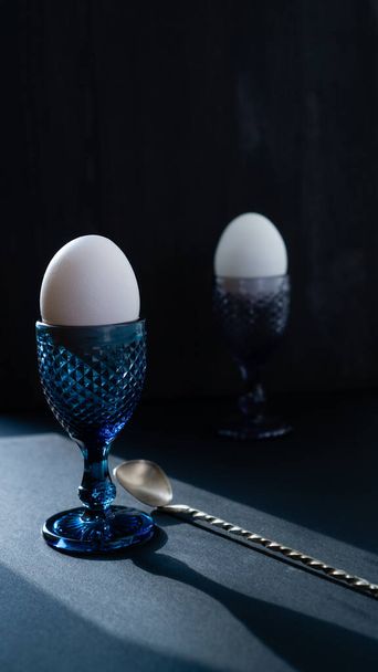 Cam bardakta beyaz yumurtalar ve desenli bir yüzey. Sağlıklı dengeli kahvaltı yumurtaları. - Fotoğraf, Görsel