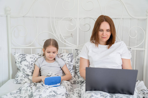 stay home girl and mom learn on computer in bed - Фото, зображення