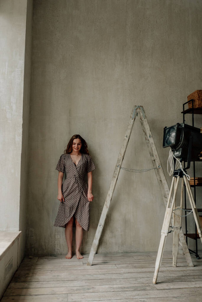 mooie vrouw in stijlvolle kleding poseren op zolder   - Foto, afbeelding