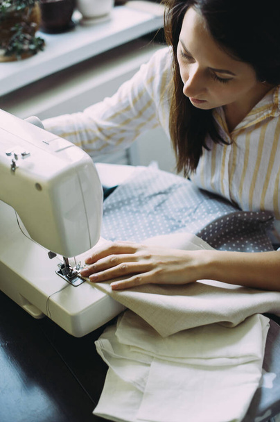 seamstress works on a sewing machine. factory. handmade - 写真・画像