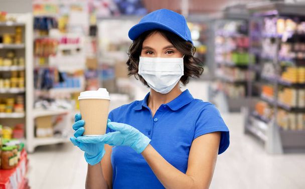 saleswoman in mask with coffee cup at store - Foto, Imagem