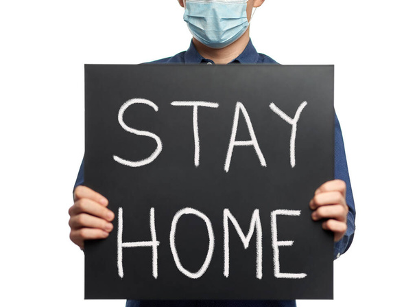 Man with face mask and blackboard with #stayhome message - 写真・画像