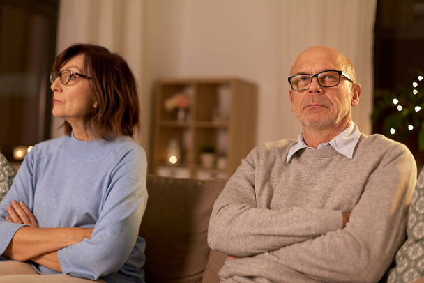 unhappy senior couple sitting on sofa at home - Foto, Bild