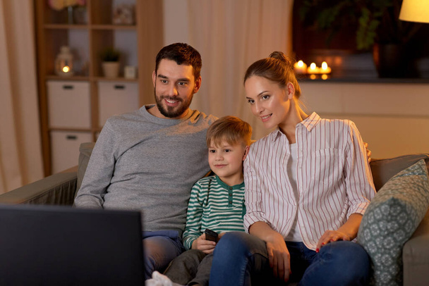 happy family watching tv at home at night - Foto, afbeelding