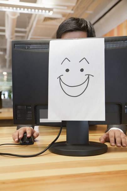 γελαστό πρόσωπο στον υπολογιστή στο γραφείο - Φωτογραφία, εικόνα