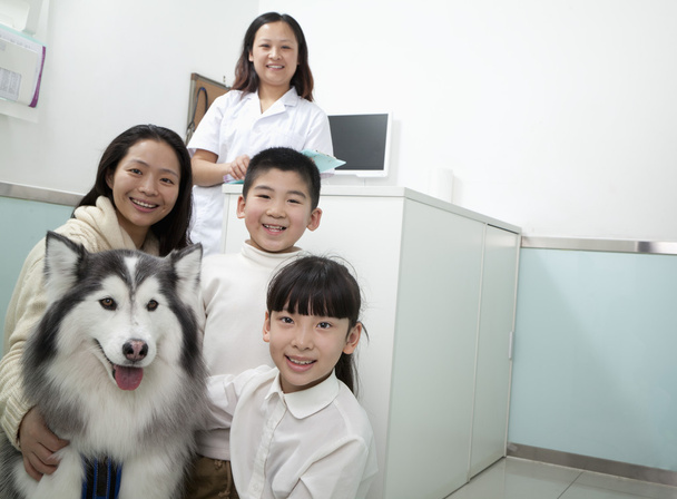 familie met huisdier hond in de dierenarts kantoor - Foto, afbeelding