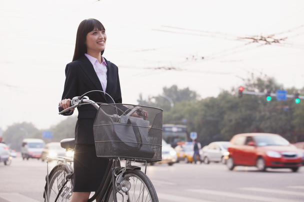 Businesswoman riding a bicycle - 写真・画像