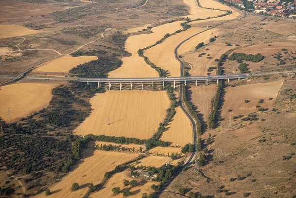 Aerial view of the Madrid region, outside the metropolitan area. Flying over agricultural fields and road. Spain - Φωτογραφία, εικόνα