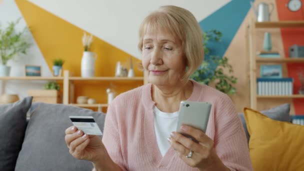 Senior woman shopping online making electronic payment with bank card and smartphone - Záběry, video