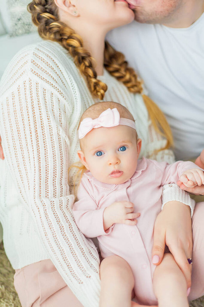 Güzel, genç ebeveynler yeni doğmuş kızlarını kollarında tutuyorlar. 2 aylık mavi gözlü küçük kız.. - Fotoğraf, Görsel