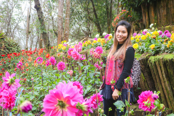 Азиатка путешествует в зимнем цветочном парке Чаинг Рай, Таиланд. Азиатская женщина наслаждается отдыхом в цветочном саду
. - Фото, изображение