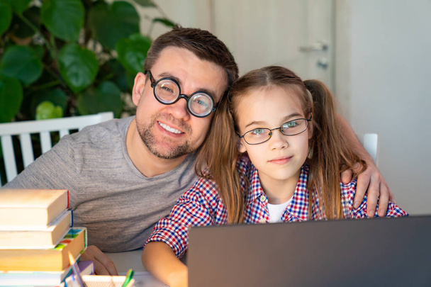 dad in glasses helps kid girl distance learning - Photo, Image