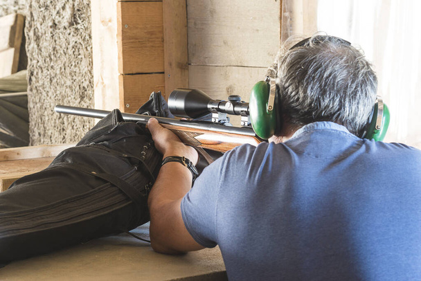 Muži ve sluchátkách pohled zpět střílet s karabinou s optickým zrakem - Fotografie, Obrázek