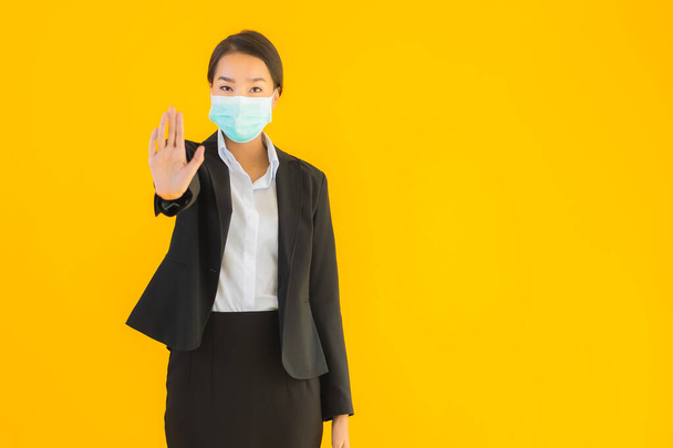 Portrait beautiful young business asian woman wear mask for protect covid19 coronavirus on yellow isolated background - Foto, Bild