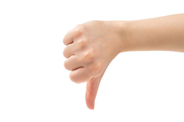 Pulgar hacia abajo signo de mano femenina aislado sobre un fondo blanco. Símbolo comunicación gesto objeto
 - Foto, Imagen