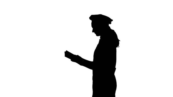 Silhouette noire de chef dame aux cheveux longs livre de cuisine de lecture
. - Photo, image