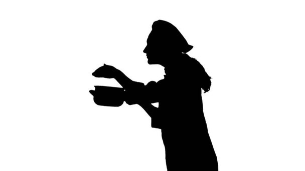 Portrait of black silhouette of a chef female in uniform smelling dish. - Foto, Imagen