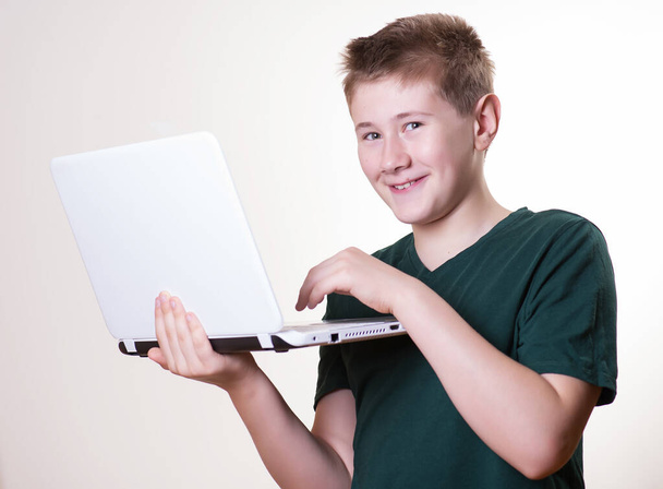 excited 10 - 12 years old boy (teenager) use his laptop - Fotó, kép