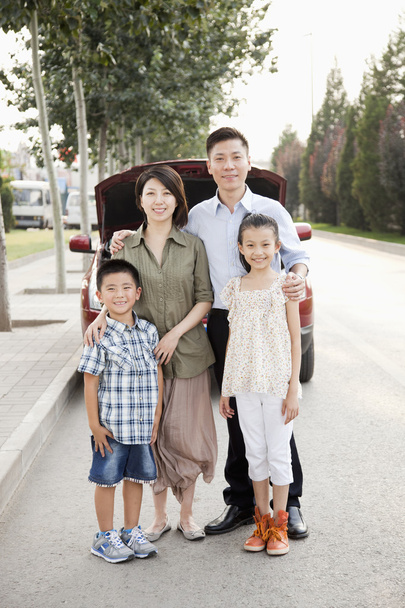 Retrato familiar delante del coche en la carretera
 - Foto, Imagen
