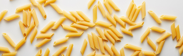 Panoramic shot of uncooked pasta on white background  - Photo, Image