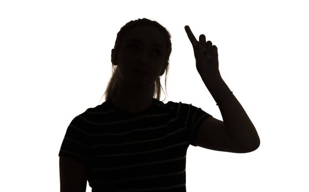 silhouette of a thinking girl showing thumb up on a white isolated background, finding an idea, mental process - Foto, Imagen