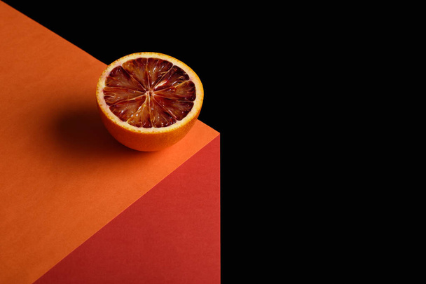 abstraktes Bild von roter Orange auf illusionärem Würfel auf schwarzem Hintergrund mit Kopierraum - Foto, Bild