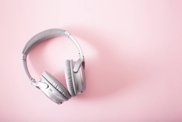modern silver wireless headphones on pink background - Foto, Imagen