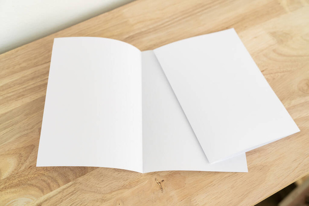 A4 half-fold brochure blank white template for mock up and presentation design on wooden surface.  - Fotó, kép