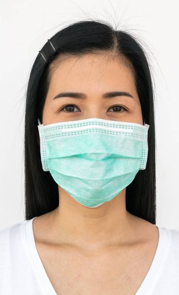 A woman wears a face mask that protects against the spread of Coronavirus (COVID-19). Surgical mask. Medical mask. Face mask. - Фото, зображення