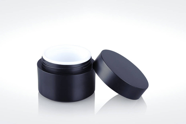 Black shiny cosmetic jar isolated on background - Photo, Image