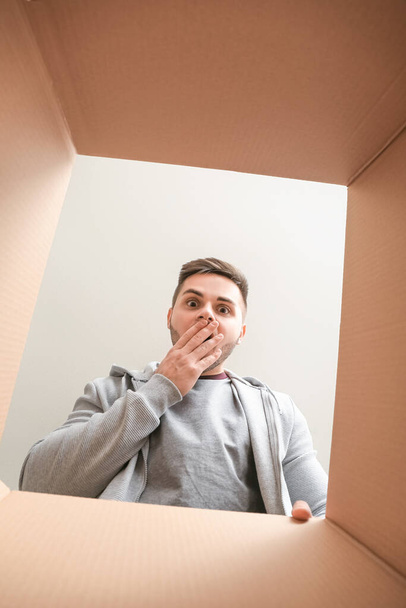 Shocked man with open box, view from inside - Photo, image