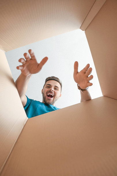 Glücklicher Mann mit offener Kiste, Blick von innen - Foto, Bild