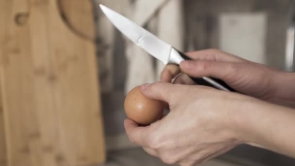 Primo piano di mani di donna rompere l'uovo con un coltello e mettere bianco crudo e tuorlo nel purè di patate, concetto di cottura. Azione. Purè di patate con uova in un piatto profondo in cucina
. - Filmati, video